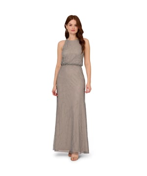 Timelessly sparkle at your next formal event in this blouson gown. This formal dress features a sleeveless blouson bodice, a halter neckline, and a mermaid skirt. Fully lined, this evening gown is designed with mesh knit fabric that is fully embellished with sequin and beaded floral deco patterns. A hidden zipper closure at the centre back completes this sleeveless gown. Paired with nude heels and simple accessories, this beaded dress is ideal for black-tie events or bridal parties.