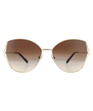 Las gafas de sol Tiffany TF3072 60213b Light Gold Brown Gradient son un precioso diseño de mariposa decorado con el distintivo diseño de hojas de trigo de Tiffany en los bordes exteriores de la montura. Hermosas patillas delgadas de metal están grabadas con el logotipo de Tiffany and CO y con punta en azul Tiffany.