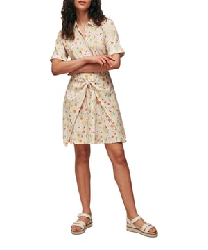 Infuse your day-to-day wardrobe with the 'Dolly Tie Front Dress', a perfectly playful piece for any casual outing. Adorned with a delightful floral pattern, this mini shift dress in creamy hues promises comfort with its soft blend of polyester and elastane.