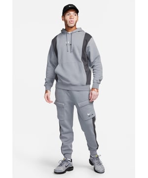 Nike Mens Panel Tracksuit Cool Grey. - - . This standard fit hoodie features a classic overhead design and is made from a soft and breathable cotton-poly fleece fabric for long-lasting comfort. - - .  It comes in silver and gray and features an adjustable hood for custom coverage and ribbed cuffs to hold the shape. - - . Featuring a kangaroo pocket for storage and the Nike Air logo on the chest. - - .  Joggers features Convenient storage and laid-back comfort. - - .  Their midweight brushed fleece feels extra soft on the inside and smooth on the outside, helping you stay cosy while keeping its structured shape. - - .  The throwback branding and pops of colour add simple but bold style.