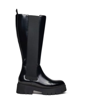Deze Hugo Kris Bootie is een hoge Chelsea-boot met hak en een chunky plateauzool, die tijdloze styling combineert met aantrekkelijke, zelfverzekerde details. De diepe instap, de ritssluiting aan de binnenkant en het gepolijste leren bovenwerk zorgen voor een gemakkelijke aan- en uittrekbaarheid en geven deze designer basic een elegante uitstraling. Deze verhogende laarzen combineren comfort met mode, waardoor ze een duidelijke verklaring van stijl en persoonlijkheid afgeven.