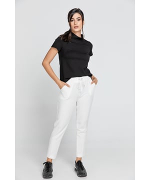 Ecru taps toelopende broek van crêpe stof. Elastische tailleband en bandjes die vooraan vastzitten. Twee zakken vooraan. Ons model is 176cm en draagt maat 36/S. Afmetingen voor maat 36/S (in cm): Taille-30, Onderkant-47, Lichaamslengte(binnen/buitenkant)-71/91. Accessoires zijn niet inbegrepen. 92% polyester-8% elastan