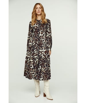 Deze jurk met dierenprint is gemaakt van geweven viscose. Het heeft een kraag en lange mouwen met manchetten in dezelfde stof met plooien. Er is een doorlopende sluiting aan de voorkant met plastic knopen toon op toon. De jurk heeft 20 cm brede plooien vanaf de taille naar beneden waardoor een los silhouet ontstaat.