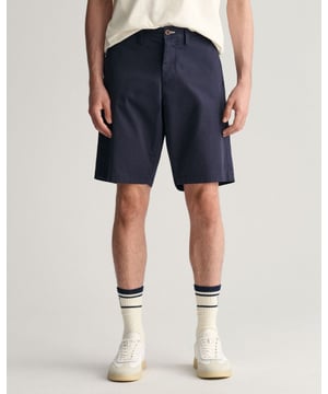 These GANT shorts are crafted from a comfortable stretch organic cotton blend with a durable twill weave structure. Designed for a relaxed fit and a mid-rise waist, they feature a stylish blue chambray lining on the waistband with cream herringbone accents, paying homage to GANT's heritage in shirtmaking. Additional details include a button front closure, a convenient coin pocket, and double welt back pockets adorned with corozo buttons. This product is made with organic cotton.

Relaxed fit
Mid rise
Comfort stretch
Back double welt pockets
Chambray waistband lining
GANT logo embroidered on back pocket

 
 Shell - 61% Organic Cotton, 37% Cotton, 2% Elastane, Pocket Lining - 100% Cotton 

205066
 
 