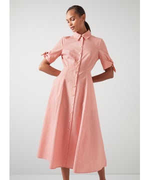 A cool cotton shirt dress is perfect for pulling on when temperatures rise, and our Saffron dress has become a firm favourite during the summer months. Crafted from a pretty pink lurex stripe cotton blend, it has a neat collar, cream buttons, short sleeves with tie detail and a flared midi skirt. Wear with a pair of slingback courts when the sun shines.