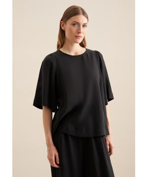 Feminin und elegant: Die Shirtbluse von Seidensticker aus der "The Connecting Neutrals" Kollektion erweitert Ihre Garderobe um ein vielseitig einsetzbares Kleidungsstück. Ob Freizeit oder Büro - sie ist ein eleganter Begleiter, der durch schlichte Eleganz überzeugt. Der mit hoher Dichte gewebte und damit besonders widerstandsfähige Leinen-Stoff ist aus 100% Leinen - ideal für pflegeleichte Outfits. Durch ihren Schnitt in Modern fit liegt die Shirtbluse nicht so eng und eher leger an und bietet so einen optimalen Komfort beim Tragen. Ein echter Hingucker, der sich als clevere Fusion aus klassischer Noblesse, im Zusammenspiel mit modernem Dessin präsentiert. An schönen warmen Tagen liegen Sie mit dieser Kurzarm-Shirtbluse stets goldrichtig. Dank dem Rundhals-Ausschnitt wird der smarte Charakter besonders betont. Zusätzlich sind edle Perlmuttknöpfe verarbeitet worden.