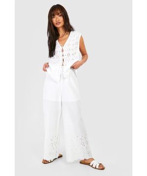 Straight-leg trousers with intricate eyelet pattern
        High-waisted design for a flattering silhouette
        Sleeveless top with daring lace-up front detail
        Wide-leg cut for effortless movement and comfort
        Versatile two-piece set perfect for mix-and-match styling
    
    Embrace laid-back chic with this eye-catching two-piece set from Boohoo. The straight-leg trousers feature an alluring eyelet pattern that adds texture and visual interest to your look. Paired with a sleeveless top boasting a daring lace-up front, this ensemble strikes the perfect balance between comfort and style. The high-waisted design of the trousers elongates your silhouette, while the wide-leg cut ensures unrestricted movement. Ideal for casual outings, family gatherings, or relaxed weekends, this set can be dressed up or down with ease. Style with flat sandals and a clutch for a daytime look, or swap for wedges and statement earrings for an evening affair. The versatility of this set allows for endless styling possibilities - wear the pieces together for a coordinated look or separately to create multiple outfits from your wardrobe.