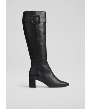 Step out in timeless elegance with the knee-high boot, the Carlotta knee boots, perfect for any occasion. Crafted from luxurious black calf leather, these boots feature a sophisticated square toe, block heel, and a stylish covered buckle. Pair them effortlessly with tailored trousers for work or a flowing dress for weekend outings. Made in Spain.