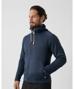 Men’s Övik Fleece Hoodie
Warm and cosy fleece jacket with a knitted exterior and a soft brushed inside. Perfect as an insulating mid layer under a shell jacket on autumn or winter adventures, and just as comfortable for long afternoons with a good book in front of the fire. It has a fixed hood with a drawcord adjustment and the zipper at the front has a protective flap in G-1000 original that protects the chin. The elbows, hem, pockets and inside of the edge of the hood also have G-1000 for extra durability. Two spacious pockets with zippers. Elastic binding at the sleeve cuffs and drawcord adjustment at the hem. The fleece and mesh lining in the pockets are made from recycled polyester and produced using an environmentally friendly process that both spins and dyes the fibres at the same time. This leads to much lower levels of water and energy consumption compared to traditional dyeing techniques.

Warm, cosy fleece jacket made from solution-dyed recycled polyester fleece.
Knitted exterior with a soft, brushed inside.
Perfect as an insulating mid layer under a shell jacket.
Reinforcements in durable G-1000 on elbows, hem, pockets and hood.
Hood with drawcord adjustment.
G-1000®: 65% polyester (recycled), 35% cotton (organic), 90% polyester (recycled), 10% polyester
Organic cotton, Recycled polyester, Better processes
Two-way zipper
Hand pocket(s)
Regular Fit
Adaptable with Greenland Wax, Durable, Insulating
40°C normal process
do not dry clean
do not tumble dry
do not bleach
iron 1 dot - Max 110°C
wash with similar colours, use a leather balm on leather details regularly

Contains non-textile elements of animal origin.
F82252