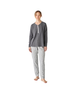 Pijama de mujer de manga larga con un diseño elegante y cómodo, ideal para descansar o relajarse en casa.

Su diseño moderno y sofisticado se adapta perfectamente a la figura femenina, realzando la silueta con un estilo chic y relajado.

El conjunto incluye una parte superior de manga larga con cuello redondo y un cierre medio con botones, que ofrece un diseño cómodo y sencillo, ideal para un estilo relajado y versátil.

El pantalón largo tiene un ajuste holgado y una cintura elástica ajustable mediante cordones para mayor comodidad. Además, incluye prácticos bolsillos laterales, perfectos para llevar pequeños objetos o simplemente para añadir un toque funcional al diseño

Toda la pijama está confeccionada en algodón, un material suave y transpirable, perfecto para cualquier época del año, garantizando frescura y confort durante el descanso.
 Composición: Camiseta: 60% Algodón, 40% Poliéster; Pantalón: 90% Algodón, 10% Viscosa
 Cuidados:
- Lavar en máquina máx 30ºC.
- Centrifugado corto.
- No usar secadora.
- Planchar máx 110ºC.