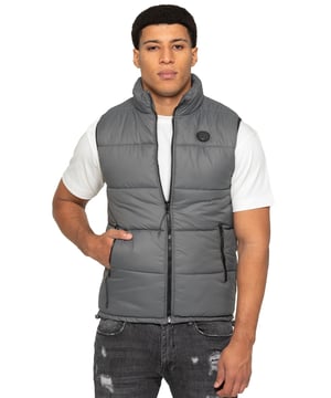 Embodying both fashion and function, the Enzo Mens Puffer Gilet boasts a water-resistant design and a high neck for added warmth. It also offers secure storage with zipped side pockets, and a custom fit with its elasticated hem and adjustable toggle. The full zip-up front and lined interior provide ultimate comfort and practicality. With a EZ branded badge on the chest, this gilet is crafted from durable 100% polyester and is conveniently machine washable.
