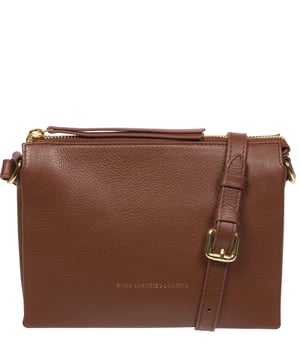 The 'Niki' cross body bag from the Pure Luxuries Marylebone collection is handcrafted from high-quality, genuine Nappa leather with a natural super-soft touch. The zip-over top opens to reveal a 100% cotton-lined interior. The spacious interor features three divided sections, a slip pocket and three card slots. The slip pocket on the rear of the bag provides on-the-go storage and comes with a matching and adjustable slim leather strap with a maximum drop length of 65cm. The Pure Luxuries logo is embossed in gold foil for a beautifully simple finishing touch.