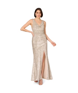 Add glamor to your next night out with this sequin gown. This formal dress features a sleeveless bodice, cowl neckline, and a mermaid skirt with a side slit. Made from stretch sequin fabric, this gown is fully lined and ultra comfortable. Gathered details at the sides creates a beautiful, shirred effect, which flatters the figure. A side zipper closure completes this evening gown. Style this sequin dress with nude heels and a satin clutch for a look that will belong in any room you walk into.