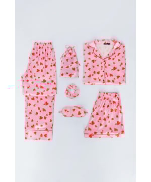 Getting cozy. Feel luxe in our 6 piece pajama set, which includes a button up pajama top, shorts, long pajama pants, and a matching scrunchie, eye mask, and bag, all made in a high quality satin fabric. Pairs well with lazy evenings and movie nights.6-pc Satin Heart Print Pajama SetHigh Quality Satin Fabric6 Piece Pajama SetCute Heart PrintButton Up Pajama TopPajama Shorts and PantsMatching Eye Mask, Scrunchie, and Bag Model wears a size M (US size 6/UK size 10).