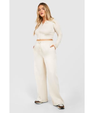 Ribbed texture for added visual interest and comfort
        Crop top with double zip detail for versatile styling
        Straight-leg joggers for a modern, relaxed silhouette
        Coordinated set perfect for effortless outfit creation
        Plus size design ensuring inclusive fashion for all
    
    Embrace laid-back luxury with this plus-size ribbed tracksuit from Boohoo. The long-sleeved crop top features an eye-catching double zip detail, allowing for customisable coverage and style. Paired with straight-leg joggers, this set offers a contemporary twist on classic loungewear. The cotton-blend fabric ensures breathability and comfort, making it ideal for casual outings or relaxed days at home. Style with chunky trainers and a crossbody bag for an on-trend street look, or dress it up with statement jewellery and heeled boots for a night out with friends. This versatile set is perfect for the fashion-forward woman who values both comfort and style in her everyday wardrobe.