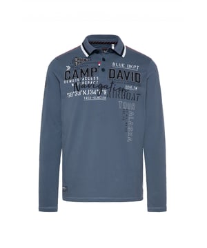Deze winterversie van de polo is een klassiek en veelzijdig kledingstuk. Het heeft lange mouwen en een normale pasvorm. De knoopsluiting met drie knopen zorgt voor de typische pololook. De contrasterende strepen op de kraag zorgen voor een sportieve en moderne look. De kraag is ook aan de onderkant bedrukt. De verschillende bedrukte, geborduurde en opgenaaide labelversieringen zijn een visueel hoogtepunt. Contrasterende naden op de schouders en zijkanten ronden het ontwerp af.