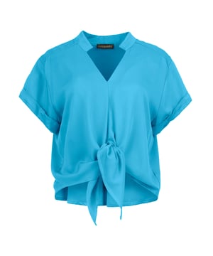 Esta blusa de manga corta Cerulean Charm Viscose Tie-Front Blouse está confeccionada en tejido de viscosa. Tiene escote en V y cuello alto. Tiene mangas cortas con vuelta. Presenta una costura vertical en la parte delantera que culmina en lazos que se abrochan delante. En la espalda hay una costura horizontal con fruncidos por debajo de la costura en el centro. El dobladillo es ligeramente redondeado en la espalda.
