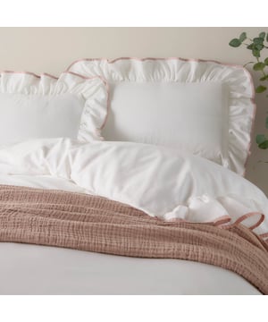 Transform your bedroom into a serene retreat with the Blousey Pillowcases. Crafted from 100% cotton sateen with a luxurious 180 thread count, these pillowcases are as soft as they are stylish. A subtle yet elegant ruffled trim, accentuated by a delicate piped detail, adds a touch of timeless sophistication to your bedding ensemble. Perfect for layering with textured throws or cushions, they create an effortlessly cosy yet refined aesthetic that complements both minimalist and relaxed interiors. These pillowcases not only enhance your bedroom’s visual appeal but also provide a breathable, comfortable surface for restful sleep.