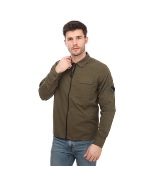 Mens C.P. Company Gabardine Zipped Shirt in khaki.- Pointed collar.- Zip fastening.- Chest pocket.- Adjustable cuffs.- Iconic lens detail on the sleeve pocket.- Regular fit.- 100% Cotton.- Ref: 16CMSH158A683
