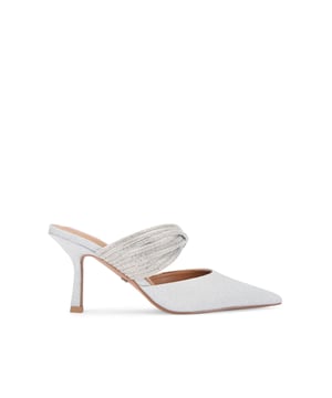 The KG Kurt Geiger Aisha Mule heel features a silver glitter fabric upper with exaggerated pointed toe. There are multiple straps across the foot which are embellished with silver crystals. Heel height: 8cm.