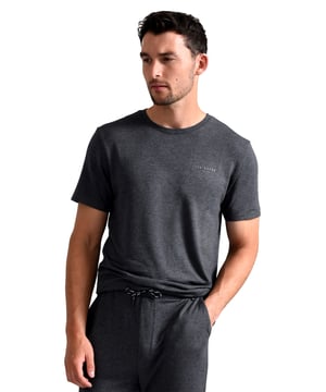 Ted Baker Kurzarm-Pyjama-Oberteil

Das Ted Baker Kurzarm-T-Shirt-Pyjama-Oberteil ist eine luxuriöse und bequeme Ergänzung Ihrer Nachtwäsche-Kollektion. Hergestellt aus einer Mischung von 93% Modal und 7% Elastan, ist dieses Pyjama-Oberteil unglaublich weich und dehnbar und bietet maximalen Komfort und Flexibilität während des Schlafs. Der Stoff ist zudem atmungsaktiv, sodass Sie die ganze Nacht über kühl und bequem bleiben.

Erhältlich in drei Größen: medium, large und x-large, sowie in vier Farben, einschließlich Anthrazit, Marineblau, Burgunderrot und Grün, ist dieses Pyjama-Oberteil perfekt für jeden Stil und jede Vorliebe. Das klassische Design verfügt über einen Rundhalsausschnitt und kurze Ärmel, was es einfach macht, es mit jeder Pyjamahose zu kombinieren.

Einer der Hauptvorteile dieses Pyjama-Oberteils ist das hochwertige Material. Die Modal- und Elastan-Mischung ist nicht nur weich und bequem, sondern auch strapazierfähig und langlebig. Das bedeutet, dass Sie es nicht so oft ersetzen müssen, was es langfristig zu einer kostengünstigen Wahl macht.

Darüber hinaus ist das Ted Baker Kurzarm-T-Shirt-Pyjama-Oberteil vielseitig und eignet sich nicht nur für Nachtwäsche. Sie können es auch als lässiges Oberteil zum Entspannen zu Hause oder beim Erledigen von Besorgungen tragen. Das klassische Design und die Vielzahl an Farben machen es einfach, es mit jedem Outfit zu kombinieren.

Zusätzliche Produktdetails
- Ted Baker
- Kurzarm-PJ-Oberteil
- Luxuriöse Nachtwäsche
- 93% Modal Baumwolle
- Strapazierfähig