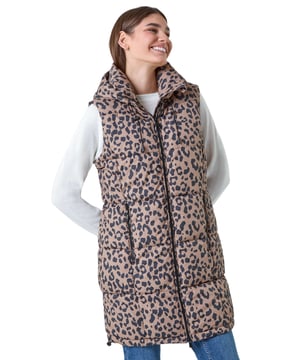 Animal Print Longline Hooded Gilet from Roman. Gilets are the perfect option for the transitional seasons, providing just the right amount of warmth for unpredictable weather. Cut from a woven fabric this gilet features a cosy funnel neck and a front zip fastening for a secure fit. A practical hood is finished with a drawstring cord for an adjustable fit, while zipped pockets provide space for your everyday essentials. Adorned in a fun animal print this piece is padded for extra warmth. Pair with relaxed denim and knitwear with either boots and trainers for trendy everyday style!