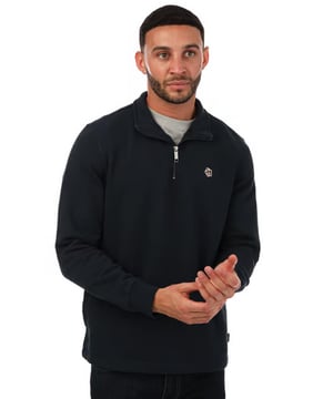 Actualiza tu vestuario casual con el suéter de media cremallera para hombre Ted Baker Kilburn en gris. Con un elegante cuello alto y cierre de media cremallera para mayor comodidad, este suéter ofrece tanto estilo como confort. Incluye puños y dobladillo acanalados para un ajuste perfecto, mientras que el adorno de Magnolia característico agrega un toque refinado. Hecho de 100% algodón, esta prenda de ajuste regular es ideal para el día a día