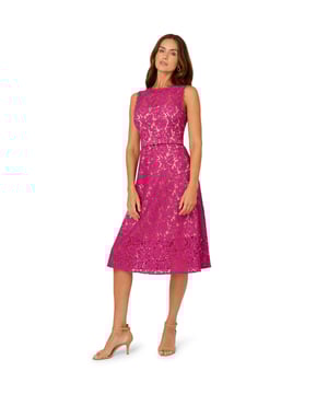Dressy by day, flirty by night, this lace dress is a charming look. This fit and flare dress features a crew neckline, sleeveless bodice with sheer lace at the yoke, and a belted waist. Partially lined with contrasting fabric, this midi dress is crafted from lace that is sheer at the neck and hem. This party dress is closed with a zipper at the centre back. Complete the look for a day at the office or a night out with nude heels and sparkling jewels.