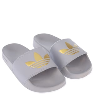 Womens adidas Originals Adilette Lite Slide Sandals in grey.<BR><BR- Single bandage synthetic upper.<BR>- Slip-on construction.<BR>- The inner insole  contoured to the shape of the foot.<BR>- Decorated with large gold Trefoil logo on the top.<BR>- Rubber outsole.<BR>- Synthetic Upper  Synthetic Lining  Synthetic Sole.<BR>- Ref.: FW0542