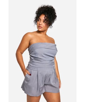 Chic bandeau neckline for a sleek, strapless look
        Flattering ruched detailing accentuates curves
        Versatile playsuit design perfect for day-to-night wear
        Comfortable elasticated waistband for a secure fit
        Practical side pockets add functionality to style
    
    Embrace effortless elegance with this stunning plus-size bandeau playsuit from Boohoo. The ruched detailing adds a touch of sophistication while flattering your curves in all the right places. Perfect for transitioning from day to night, this versatile piece can be dressed up or down with ease. For a chic daytime look, pair with flat sandals and oversized sunglasses. When the sun sets, swap your flats for strappy heels and add statement earrings to take your outfit from desk to dinner. The playsuit's comfortable fit and practical pockets make it ideal for various occasions, from casual brunches to evening cocktails. Layer with a cropped jacket for cooler evenings or rock it solo to show off its sleek silhouette. With its blend of style and comfort, this playsuit is sure to become a go-to favourite in your wardrobe.