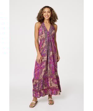 Add a statement print to your holiday closet with this maxi sun dress. It has a self-tie halter neck, sleeveless fit and a tiered maxi length skirt. Pair with flat sandals for an elegant poolside style, or elevate with heeled espadrilles for an evening out.
