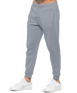 Experience ultimate comfort in our Enzo Mens Regular Fit Joggers. Made with a soft brushed back inner fleece lining, these joggers are perfect for casual wear. The cuffed leg design and elasticated waist with drawstrings provide the perfect fit. With 2 side slash pockets, you can easily carry your essentials.