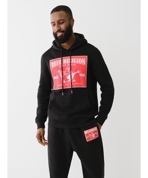 Cozy up in the Ladder Stitch Logo Applique Hoodie. Crafted from fleece-lined fabrication, this hoodie features a front True Religion Buddha logo applique with ladder stitch trim. Finished with a drawstring hood, kangaroo pocket, long sleeves, and ribbed trim.