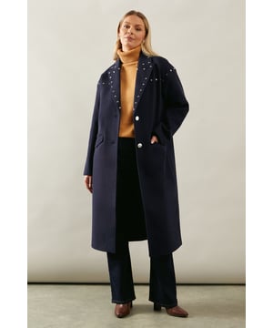 Elegant midi-length wrap coat with studded detailing
        Sophisticated notched lapels adorned with eye-catching studs
        Two-button front closure for a customisable fit
        Practical flap pockets at the hips
        Versatile design suitable for various smart occasions
    
    Embrace sophistication with this stunning studded wrap midi coat from Wallis. Perfect for the woman who appreciates glamour without compromising on comfort, this coat is a versatile addition to any wardrobe. The midi length offers coverage and warmth, while the wrap style allows for a flattering silhouette. Style it over a grey turtleneck and dark trousers for a chic daytime look, or drape it over an evening dress for a touch of elegance at formal events. The studded detailing adds a subtle edge, making this coat a standout piece for smart-casual gatherings or sophisticated soires. Whether you're attending a business meeting or heading to a dinner party, this coat will ensure you look polished and feel confident.