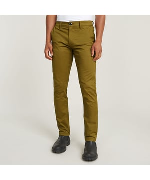 Zip fly. Inset pockets with a broad welt. Coin pocket caught in the side seam. Single welt back pockets, one with a button. Vertical seams add shape to the back side. Zip & button closure. Mid waist. Chino Slim is G-Star RAW's interpretation of a slim fitted chino, enhanced with engineered seams that are placed aligned with the side seam itself. The coin pocket is integrated in the side seam. Broad welt pocket inserts complete the chino look. 98% Cotton, 2% Elastane. Comfortable stretch. Slim