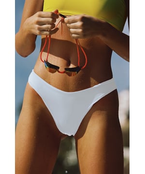 Classic 80s glamour comes to mind with this white seamless bikini bottom — perfect for poolside hangs or deep dive endeavours. Inject some colour and contrast your look with the yellow cut-out one-shoulder bikini top for full impact.