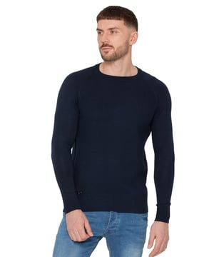 Der Enzo Milano Rundhals-Strickpullover ist ein stilvolles und gemütliches Must-Have in Ihrer Garderobe, perfekt für kühlere Tage. Mit einem strukturierten Strickdesign verleiht dieser Pullover jedem Outfit Tiefe und einen Hauch von Raffinesse. Der klassische Rundhalsausschnitt lässt sich mühelos mit lässigen und smart-casual Looks kombinieren, während die gerippten Bündchen, der Saum und der Kragen eine bequeme, eng anliegende Passform bieten, die ihre Form behält. Ein elegantes Enzo-Plakettenschild in der Nähe des Saums fügt eine subtile, aber markante Markenunterschrift hinzu und betont die hochwertige Verarbeitung. Dieser vielseitige Strickpullover ist ideal für alle, die Komfort und Stil in ihrer Alltagskleidung kombinieren möchten.