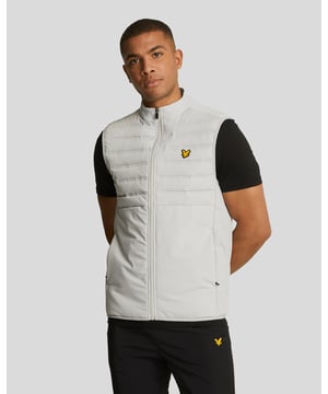 The perfect extra layer whatever sport you’re involved with, this hybrid gilet will also look sharp when the training is done. It features quilted panels for added insulation and is made from a versatile nylon and elastane blend for added stretch and ease of movement. It does up at the front with a zip fastening. - Front zip fastening 
- Quilted panel at the front 
- Side zip pockets 
- Elasticated hem 
- Composition: 90% nylon, 10% elastane