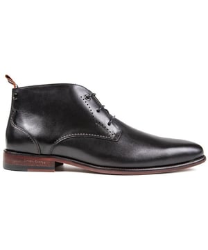 Botas chukka negras Simon Carter Collie con cordones y parte superior de cuero liso para hombre. Refuerzo del talón textil de la marca del diseñador. lengua de marca. y logo de metal en el talón. Estas botas de punta tienen un estampado exclusivo de Simon Carter Queuing Dog. Forro de piel y suela y tacón de capas sintéticas.