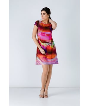 This dress is crafted in stretch print fabric, rayon-elastane. It has a round neckline and cap sleeves. There is solid colour trim at the neckline.  It has seam detail under the bust with two inverted pleats beneath both in the front and back. The dress is unlined and is styled with a loose fit.