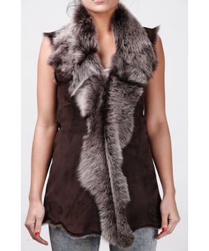 Ein hochwertiges Kleidungsstück, das perfekt geeignet ist, um in den kälteren Monaten einen eleganten Look zu bewahren und gleichzeitig warm zu bleiben. Diese Weste ist länger geschnitten und besteht aus unserem hochwertigen spanischen Toscana-Schaffell, das dafür bekannt ist, zu den wärmsten und bequemsten Wollstoffen der Welt zu gehören. Das weiche Wollfutter kann entweder mit einem Haken- und Ösenverschluss verdeckt oder in einem markanten Wasserfalldesign an der vorderen Öffnung freigelegt werden, um einen extravaganten Look zu erzielen. Damit ist es das perfekte Stück, um Ihren Winteroutfits einen Hauch von Eleganz zu verleihen. • Exklusiv im Vereinigten Königreich aus doppelseitigem Toscana-Schaffell hergestellt. • Das Toscana-Schaffellfutter bietet beispiellose Wärme und Komfort. • Außen- und Innenseite sorgfältig verarbeitet für ein weiches, seidiges Finish. • Länge: 30 Zoll.