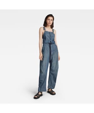 Straight front, adjustable shouderstraps with suspender buckles. Sleeveless. Reversed flap pockets at the waist, hidden snap closures and a single back pocket. Volume pleats at the outer leg, shaped knees. Wide leg, adjustable at the edge, tab with snaps. Concealed snap closure and zip fly, drawstring at the waist. Zip & button closure. Mid waist. This finely woven chambray fabric offers a characteristic color blend of blue and white. Chambray woven. LOOSE
