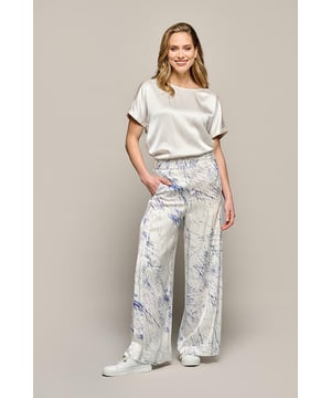 Ontdek deze prachtige pantalon met een exclusieve print! De Aiden print broek van Mart Visser is een ware blikvanger. Het patroon kenmerkt zich door een abstracte krasprint in blauw met subtiele roze accenten op een witte achtergrond. Dit moderne design, met zijn wijde, rechte pijpen, straalt pure high-fashion uit. Vervaardigd uit een lichtgewicht, luchtige viscose van hoogwaardige kwaliteit met een glanzende satijnen uitstraling. De elastische band aan de achterzijde zorgt voor extra draagcomfort. Let op de unieke ontwerpelementen, zoals de plooitjes in de tailleband, de gevoerde steekzakken en de discrete rits op het achterpand. Deze wijde damesprintbroek is een ware statement piece - precies wat je nodig hebt! Met de trendy palazzo-printbroeken van Mart Visser maak je altijd een elegante en stijlvolle indruk.