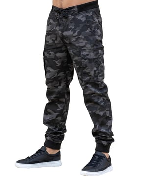 Elevate your style with ENZO's Military Combat Camouflage Cuffed Jeans. These jogger-style trousers feature an elasticated waist with drawcord and button fastening for a comfortable and secure fit. With multiple pockets and a zip fly, these mid-rise trousers offer both functionality and fashion-forward design. Perfect for the stylish, yet adventurous man.