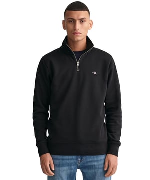 This versatile half-zip sweatshirt combines comfort and style with a premium cotton-polyester blend that's perfect for transitional weather. Featuring a small, intricately embroidered GANT graphic on the chest, it showcases a subtle yet elevated design. The ribbed hem and cuffs create a tailored silhouette. Designed for a regular fit, the half-zip collar adds a touch of sporty elegance, while the durable fabric ensures long-lasting wear.