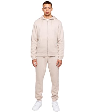 Elevate your everyday look with the Kruze Men’s Tracksuit Set, a perfect blend of comfort, warmth, and style. This set includes a regular-fit zip-up hoodie and matching joggers, both crafted with a cozy brushed-back inner fleece for a soft feel and added insulation on cooler days. The hoodie features an adjustable drawstring hood, ribbed cuffs and hem for a secure fit, and Kruze’s rubber-printed branding on the chest for a touch of signature style. Two convenient side pockets offer space for your essentials. Paired with regular-fit joggers, this tracksuit ensures all-day comfort and a sleek look. The joggers come with a ribbed waistband and adjustable drawstring for a tailored fit, two side pockets for practicality, and ribbed ankles for a streamlined, modern silhouette. A Kruze rubber print on the leg adds subtle branding.