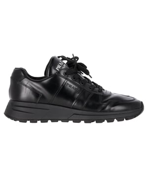 VINTAGE, UVP WIE NEU  
Gönnen Sie sich Luxus mit den Prada Prax 01 Schnür-Low-Top-Sneakern aus elegantem schwarzem Kalbsleder. Diese stilvollen Sneakers vereinen mühelos Komfort und Raffinesse und verfügen über ein klassisches Schnürdesign, das sie sowohl für lässige Ausflüge als auch für einen schicken Streetstyle perfekt macht. Das hochwertige Kalbsleder sorgt nicht nur für einen anspruchsvollen Look, sondern garantiert auch Langlebigkeit und Komfort für ganztägiges Tragen. Mit ihrer minimalistischen Ästhetik und Pradas charakteristischer Handwerkskunst sind diese Low-Top-Sneaker eine vielseitige Ergänzung Ihrer Garderobe. Kombinieren Sie sie mit alles von eleganten Hosen bis zu Ihren Lieblingsjeans für einen gepflegten, aber lässigen Look.

Prada Prax 01 Schnür-Low-Top-Sneaker aus schwarzem Kalbsleder

Zustand: Sehr gut  
Gebrauchsspuren: Leichte Abnutzungen, leicht getragen, aber sehr gut gepflegt. Kleine Markierungen an der Sohle & Faltenbildung, leichte Kratzer an der Sohle und den Fersen.  
Verpackung: Keine  
Farbe: Schwarz  
Material: Leder | Kalbsleder  
Größe: UK6.5/FR40/US7.5  
Maße: Absatzhöhe: 50; Innensohlenlänge: 290  
SKU: MRPPUGBSH397639M