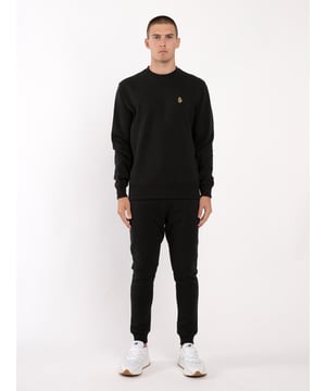 The wardrobe essential tracksuit from LUKE is cut from a soft cotton mix, fleece back fabrication ensuring warmth and comfort. The classics remain with a soft ribbed trims and both garments are completed with the brand's iconic lion head embroidery on the left side. Iconic LUKE BLACK, GOLD, RED lion embroidery. Iconic LUKE tri-colour trim tape. Ribbed neck, cuffs and hem on the sweatshirt. Ribbed waistband and cuffs on the joggers. Matte black eyelets and cord ends on the joggers. Side entry pockets on the joggers. Rear pocket on the joggers.
