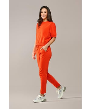 Maak kennis met de oranje joggingbroek uit de Caroline Tensen-collectie, waar stijl en comfort perfect samengaan. Deze damesbroek in joggingmodel heeft een luxueuze uitstraling door het subtiele trekkoord in de taille. Met zowel voor- als achterzakken en een modieuze, taps toelopende pijp, heeft deze broek de perfecte trendy look. Dankzij de elastische tailleband kun je de pasvorm helemaal naar wens aanpassen voor maximaal comfort. De vrolijke oranje kleur maakt de Dakota-joggingbroek een veelzijdig item dat niet mag ontbreken in je garderobe. Of je nu een relaxte outfit zoekt voor thuis, een sportieve uitstraling wilt creëren voor de sportschool of een casual-chique look nodig hebt voor je dagelijkse bezigheden, deze broek biedt de ideale oplossing. De Caroline Tensen-collectie biedt ook een bijpassende top, zodat je de broek als set kunt dragen of kunt combineren met een dames T-shirt voor een meer casual uitstraling. Gemaakt van 100% hoogwaardig katoen, voelt deze broek heerlijk zacht aan en biedt ultiem draagcomfort.