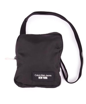 El bolso cruzado Calvin Klein Reporter es elegante. Bolso moderno y minimalista para todo tu equipaje diario. El bolso negro presenta el famoso lote del diseñador Calvin Klein Jeans New York. una correa para el hombro ajustable y un cierre de cremallera para ayudar a mantener sus objetos de valor seguros mientras está en movimiento.
